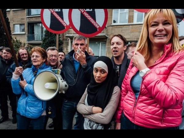 فتاة مسلمة تصور نفسها مع متظاهرين ضد الإسلام