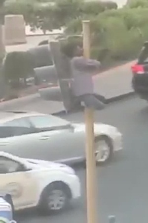 بالفيديو: شاب مخمور يتسلق إشارة مرور في الكويت!