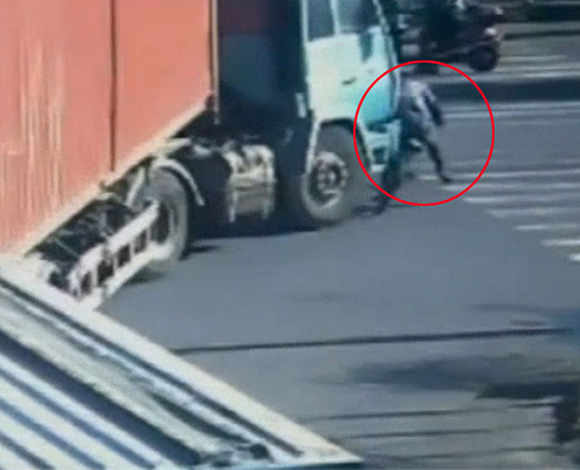 بالفيديو: سائق دراجة ينجو من الموت بعد مرور شاحنة فوقه
