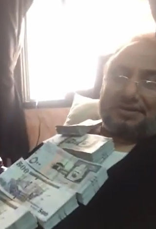فيديو: سعودي يغطي جسده برزم أموال من فئة 500 ريال!