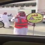 شاهد معلم يرفع لافتة أمام إحدى المدارس