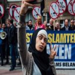 فتاة مسلمة تصور نفسها مع متظاهرين ضد الإسلام
