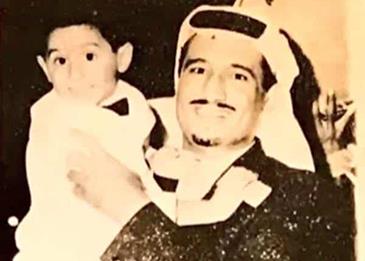 صورة قديمة في الستينيات للملك سلمان وهو يحمل ابنه الراحل الأمير أحمد